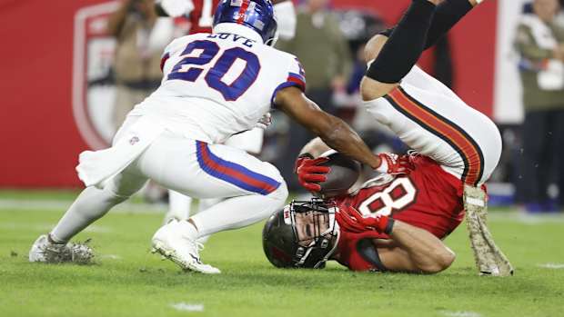 Nov 22, 2021; Tampa, Florida, USA; Tampa Bay Buccaneers tight end Cameron Brate (84) catches the ball as New York Giants cornerback Julian Love (20) defends during the first quarter at Raymond James Stadium. Mandatory Credit: Kim Klement-USA TODAY Sports